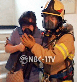 연기를 마신 한 주민이 119구조대에 의해 구조되고 있다.